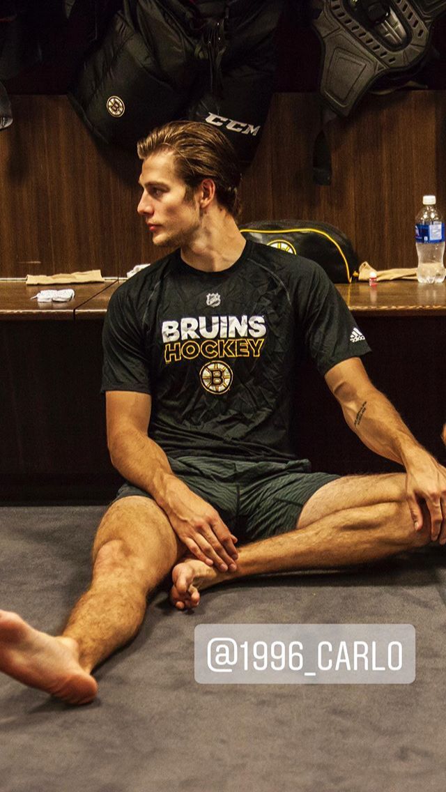 a man sitting on the floor in front of a locker room with his feet up