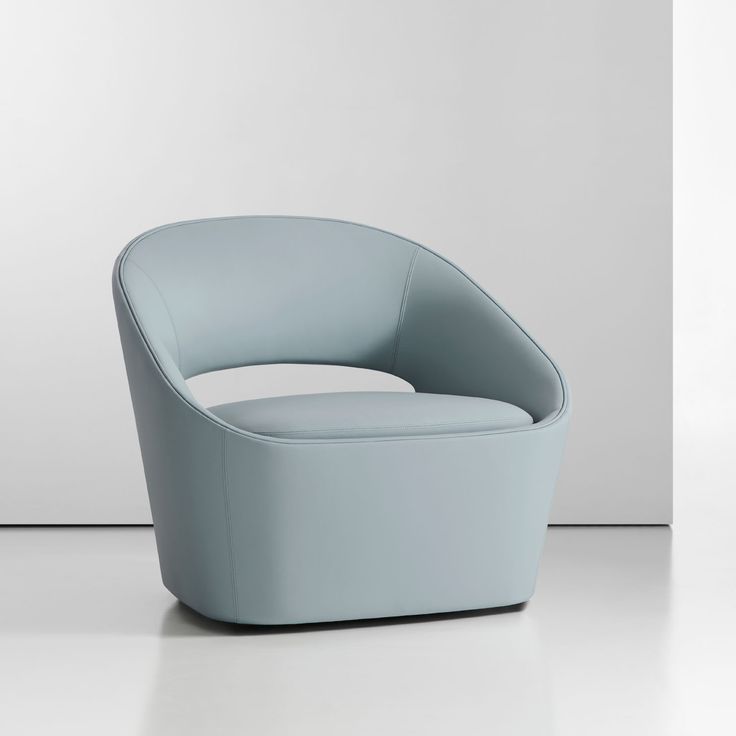 a light blue chair sitting on top of a white floor next to a gray wall