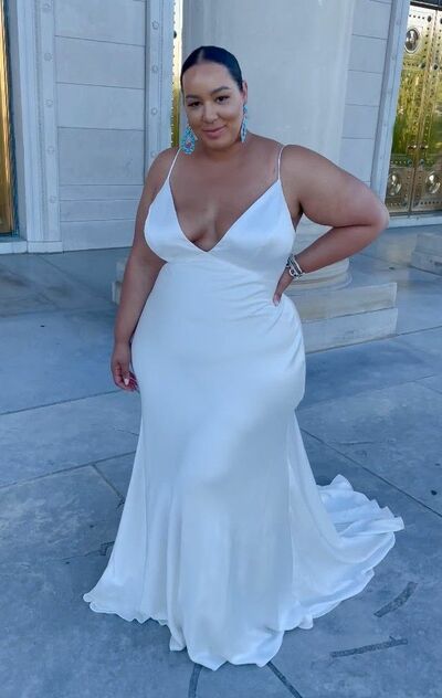 a woman in a white dress posing for the camera