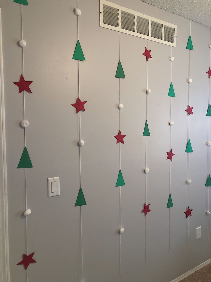 the wall is decorated with green and red christmas trees