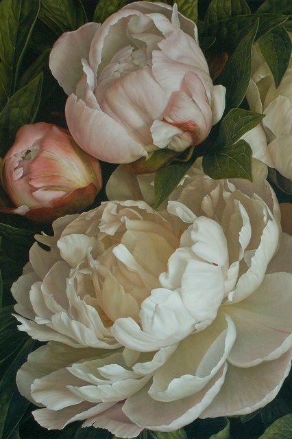 an arrangement of white and pink flowers with green leaves