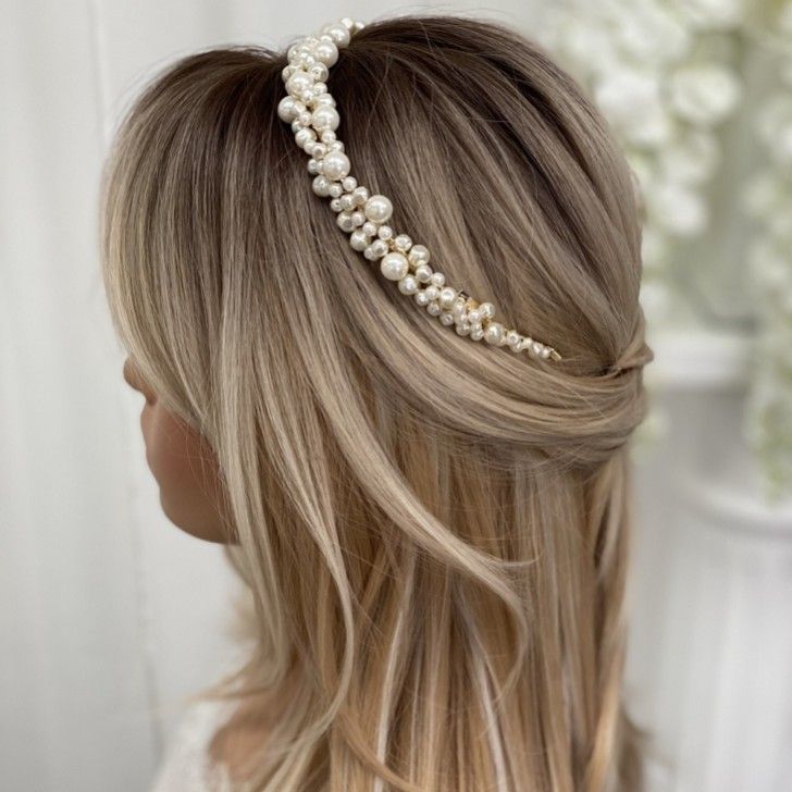 a blonde woman with long hair wearing a headband made out of pearls and beads