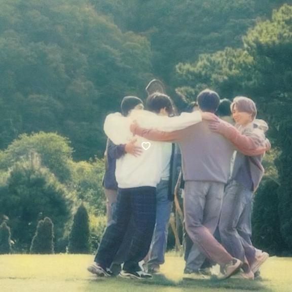 a group of young men standing next to each other on top of a lush green field