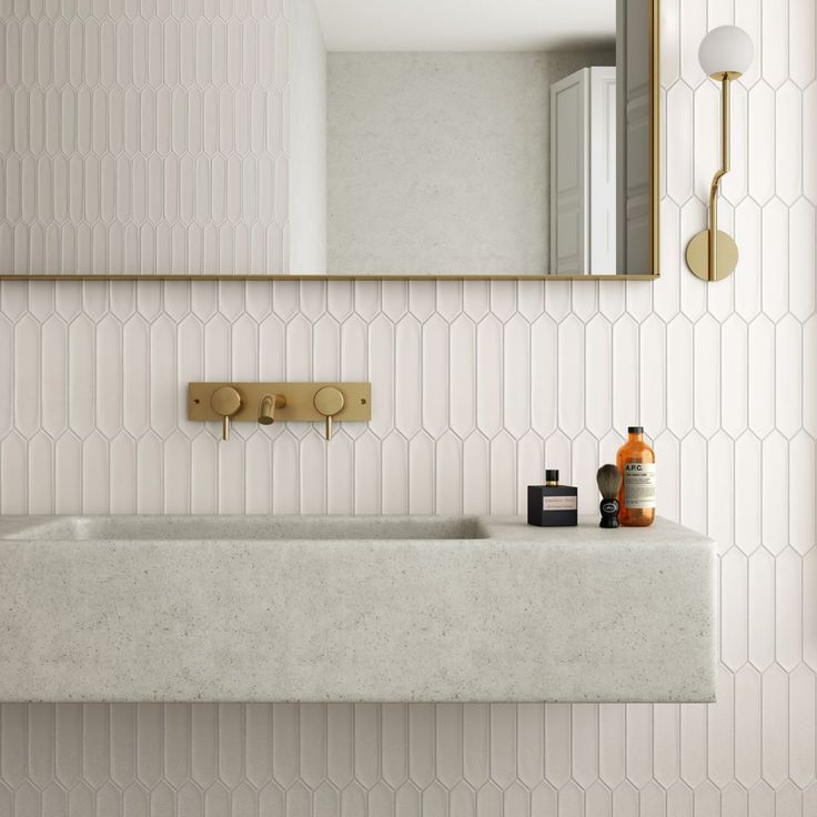 a bathroom with a sink, mirror and soap dispenser on the counter