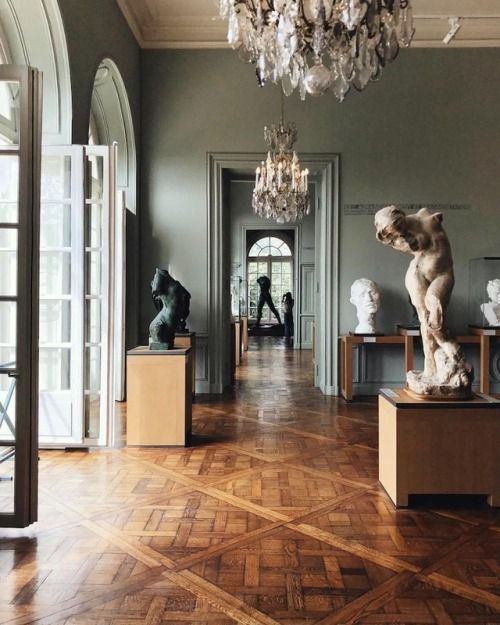 an art gallery with sculptures and chandeliers