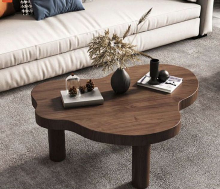 a coffee table sitting on top of a carpeted floor next to a white couch