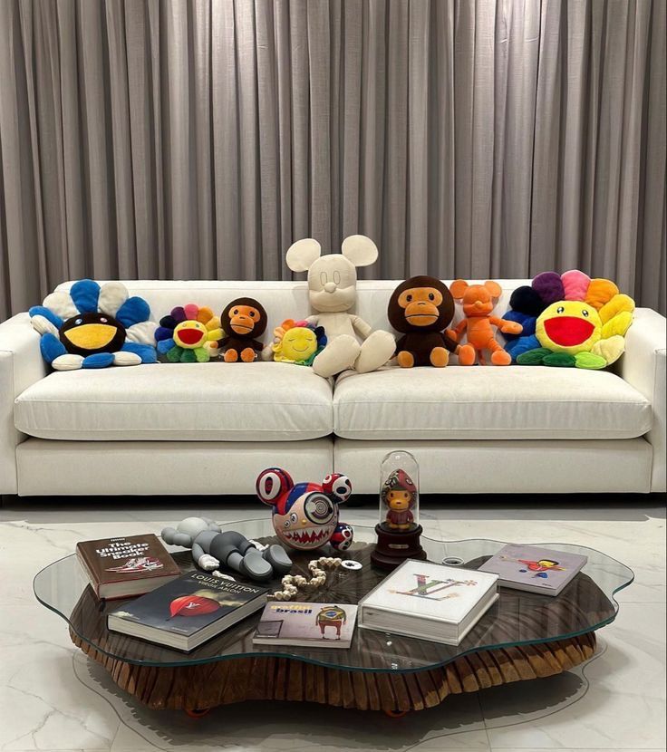 a living room with a couch, coffee table and stuffed animals on top of it