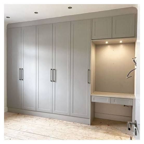 an empty room with white cabinets and drawers in the center, including a bench for storage