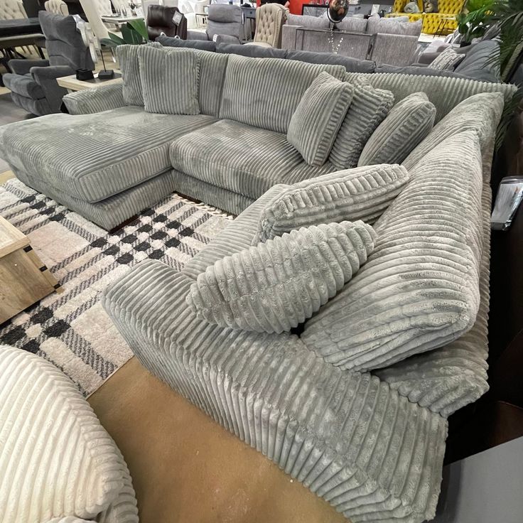 a large sectional couch is on display in a store with other furniture and decor items