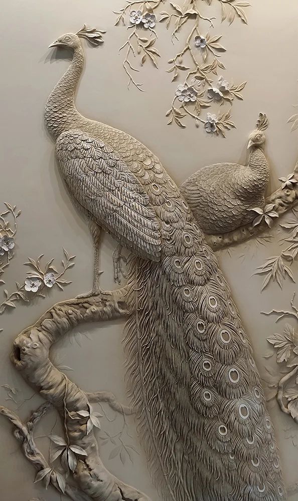 an intricately designed wall with two peacocks on it