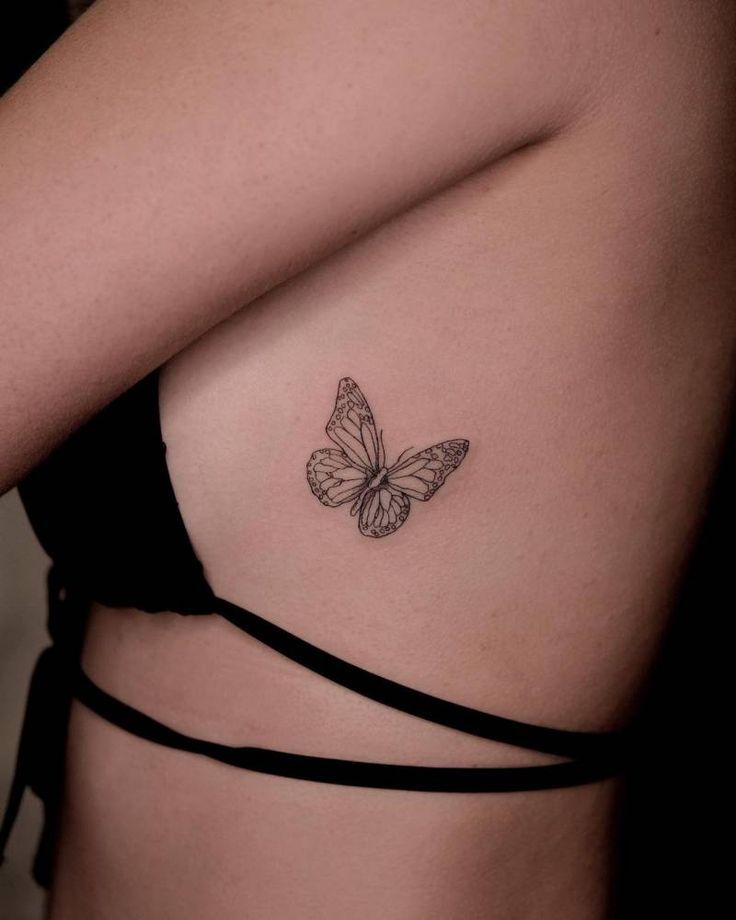 a woman with a butterfly tattoo on her chest and back side view, it looks like she is wearing a bra