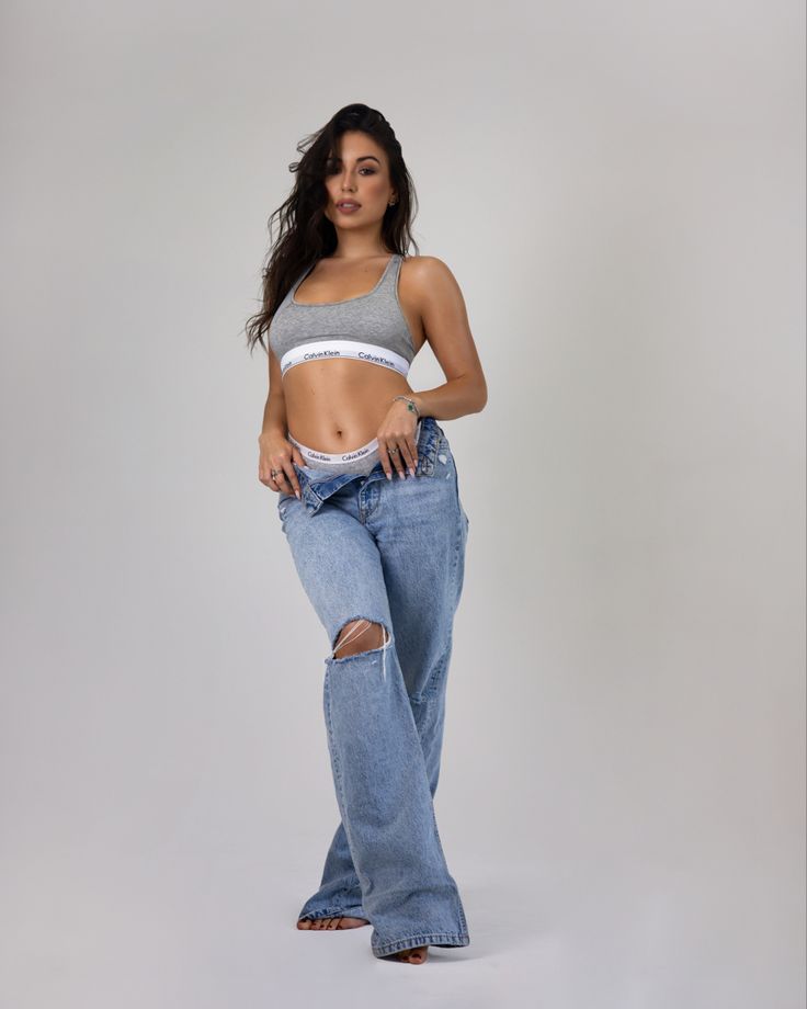 a woman posing in jeans with her hands on her hips