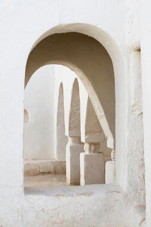 an arch in the side of a white building