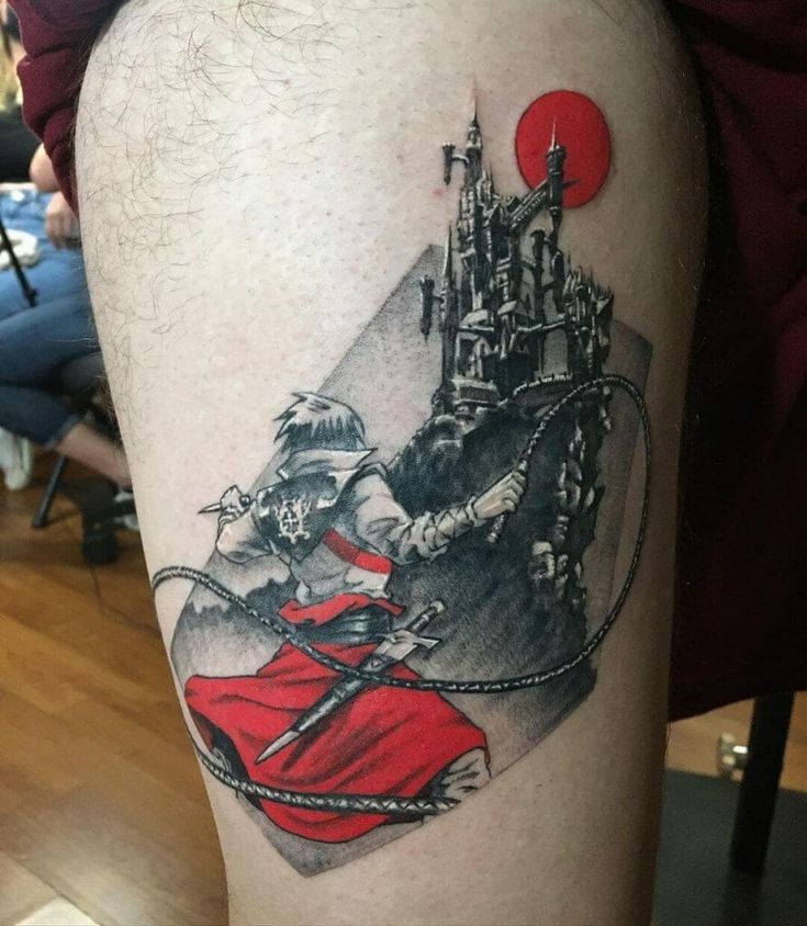 a tattoo on the leg of a person with a castle in the background and a red ball