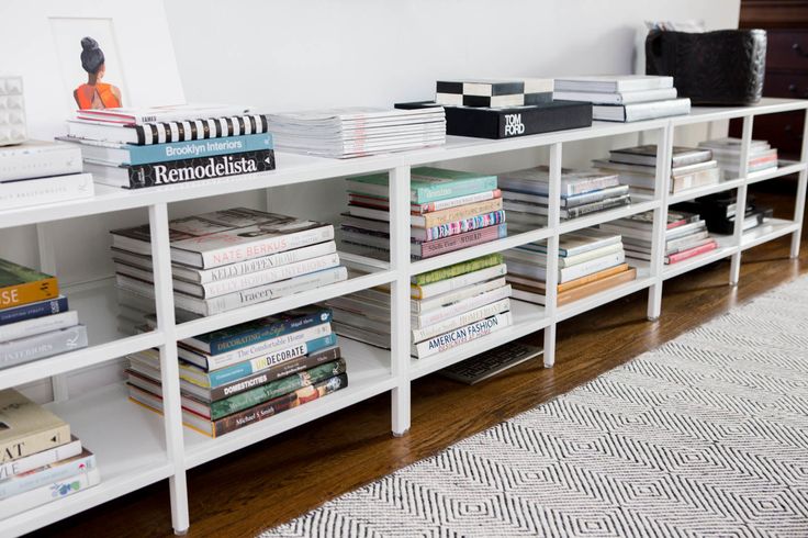 a white book shelf filled with books on top of a wooden floor