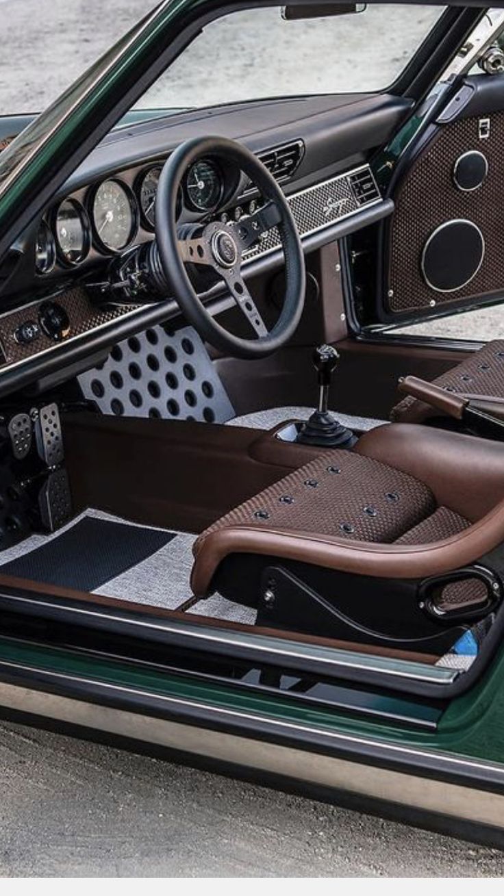 the interior of a green car with brown leather seats