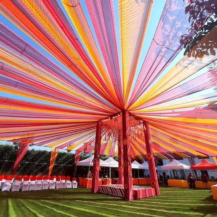 an outdoor wedding setup with colorful ribbons and chairs