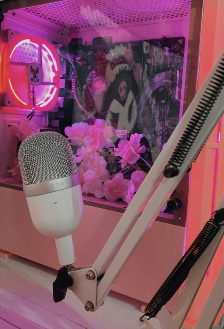 there is a microphone that is sitting on the stand in front of some pink flowers