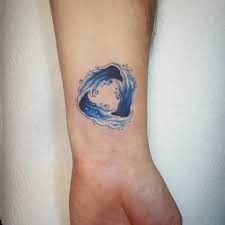 a small wave tattoo on the wrist