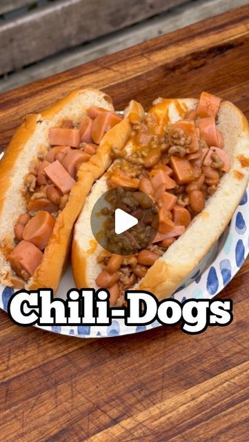 two chili dogs on a plate with the words chilli dogs in front of them