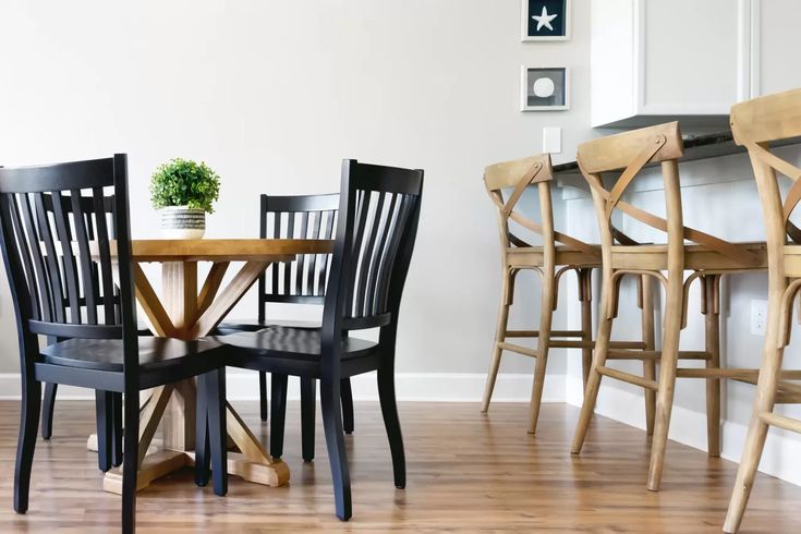 a dining room table with chairs and a potted plant