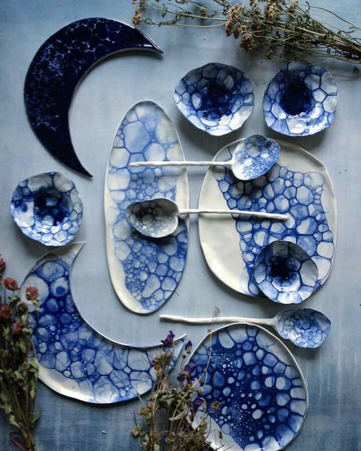 blue and white ceramic artwork on the side of a building with flowers in front of it