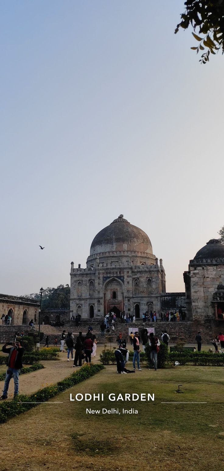 people are walking around in front of an old building with a dome on the top