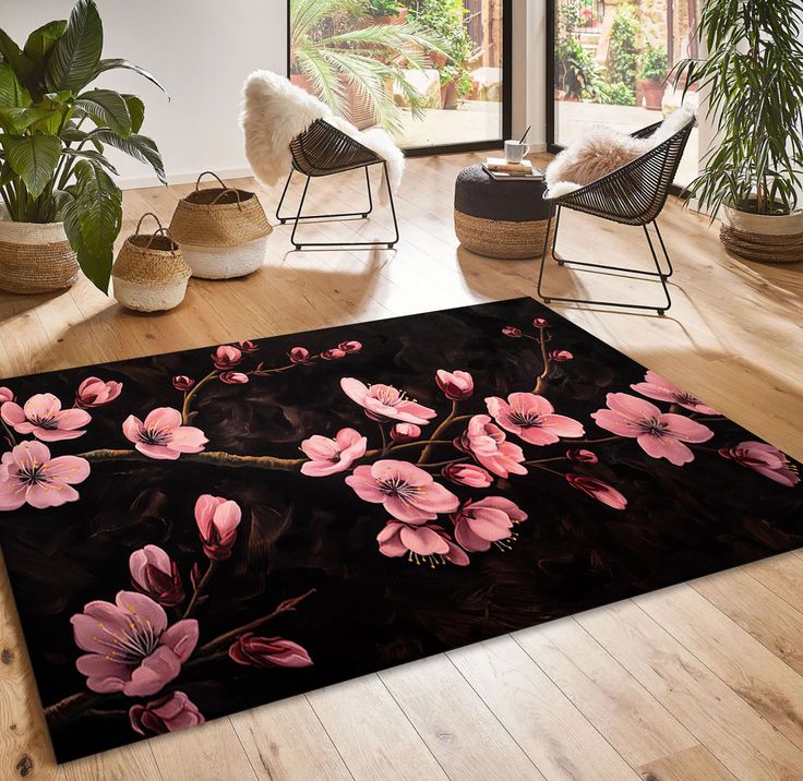 a black area rug with pink flowers on it in front of a large glass window