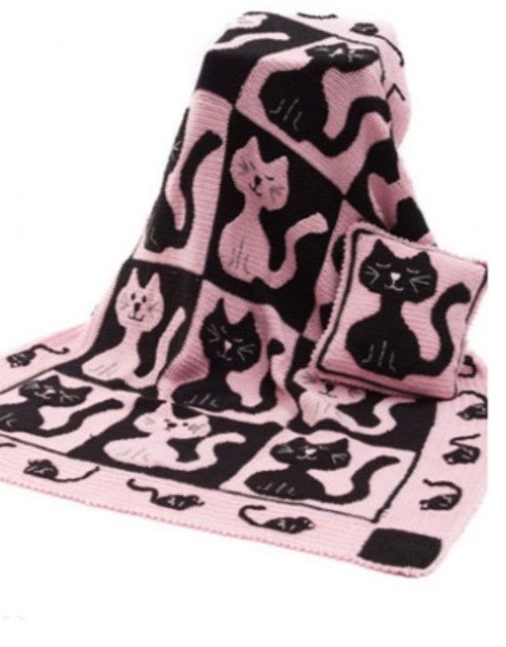 a pink and black cat blanket with matching pillows on the bottom one has two cats on it's sides