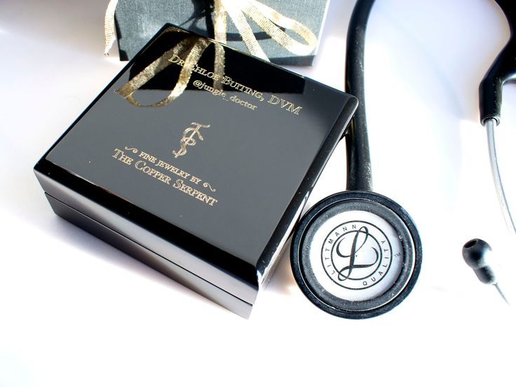 a stethoscope next to a black box with a gold ribbon