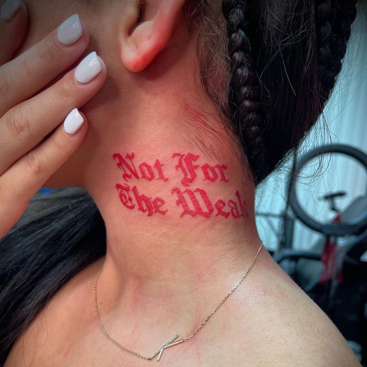 a woman's neck with the words not for the weak tattooed on her left side