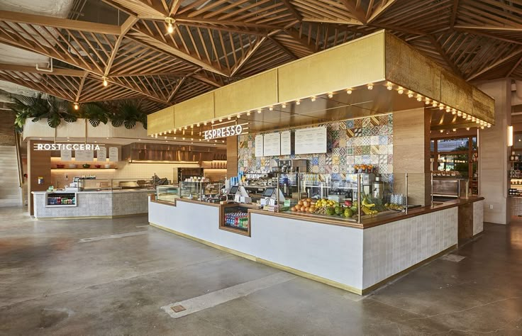 the inside of a restaurant with lots of counter space and lights hanging from the ceiling