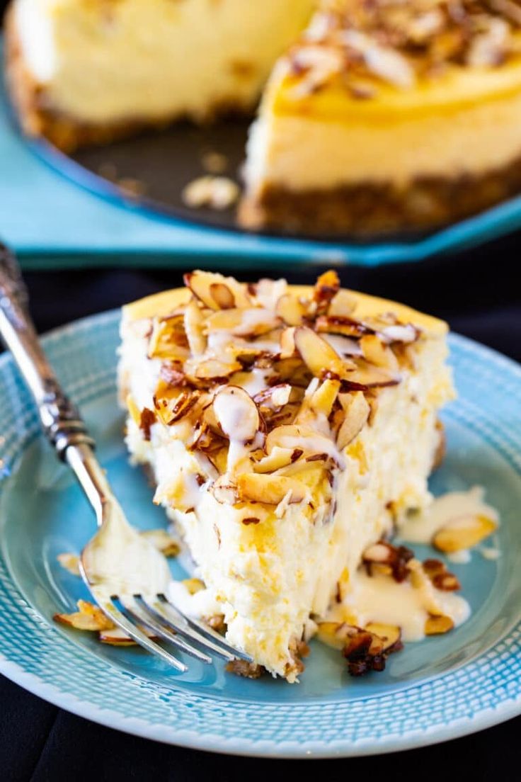 a piece of cheesecake on a plate with a fork in front of it and another slice missing