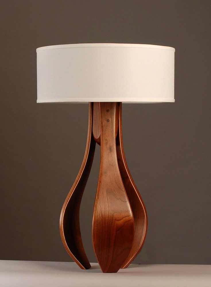 a wooden table lamp with a white shade on the top and bottom part of it