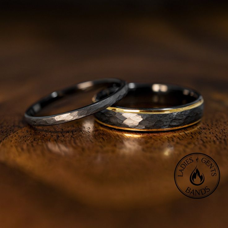 two wedding rings sitting on top of a wooden table