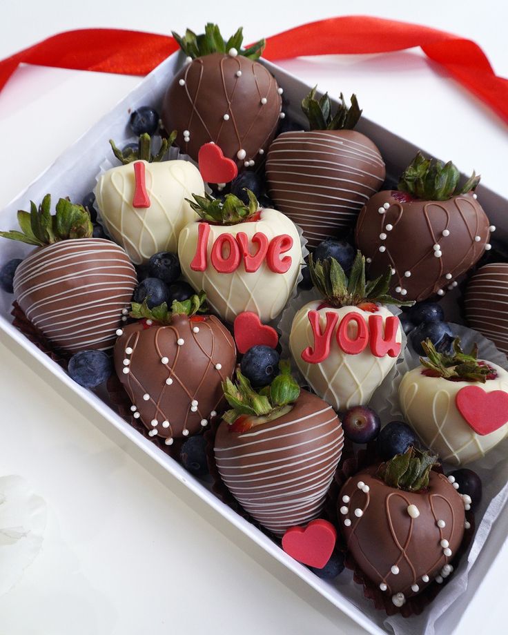 chocolate covered strawberries in a box with i love you written on the top one