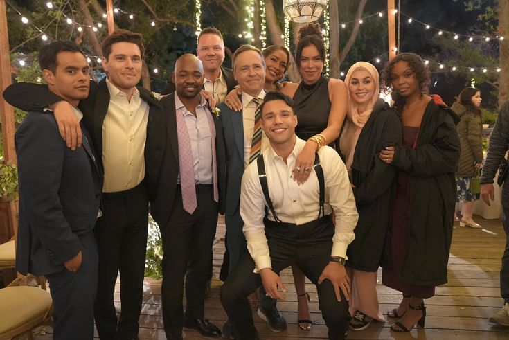 a group of people standing next to each other in front of a gazebo at night