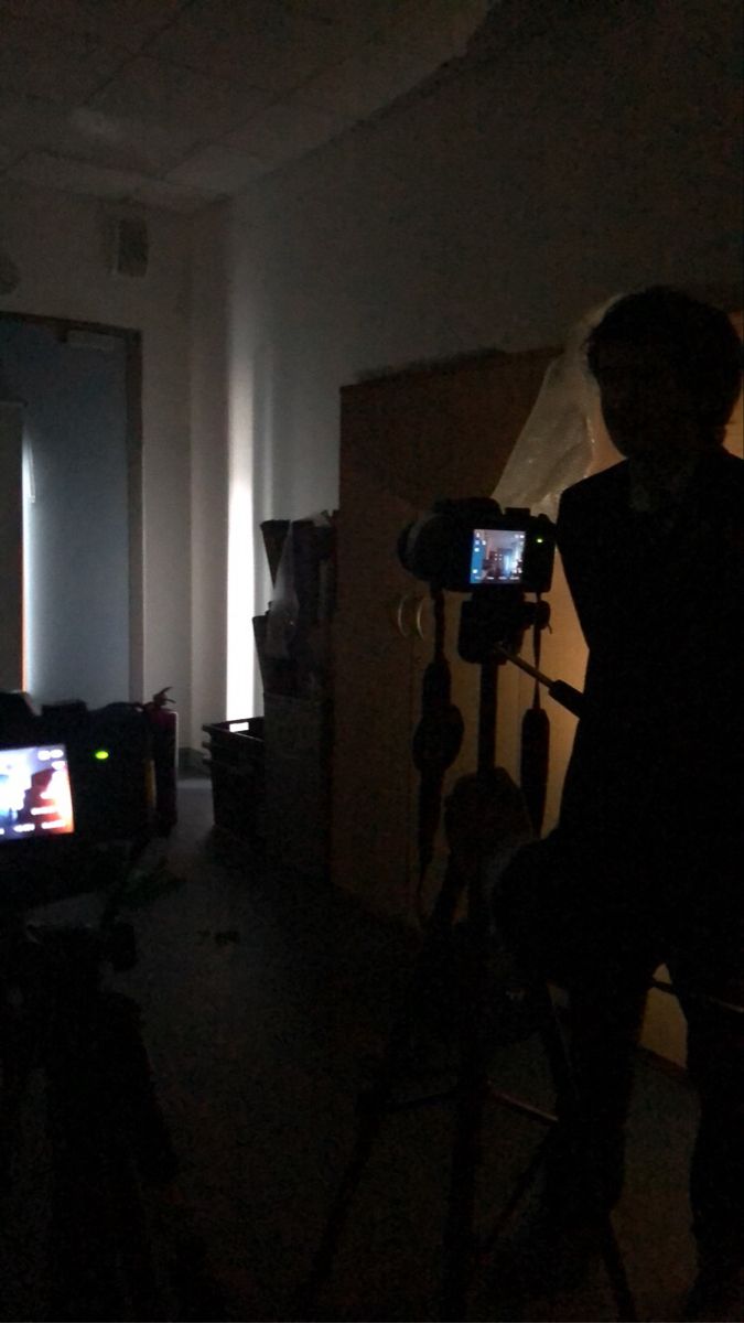 a man standing next to a camera in a dark room