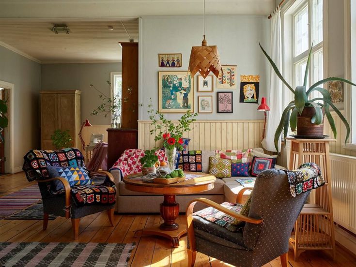 a living room filled with lots of furniture and plants on top of windowsills