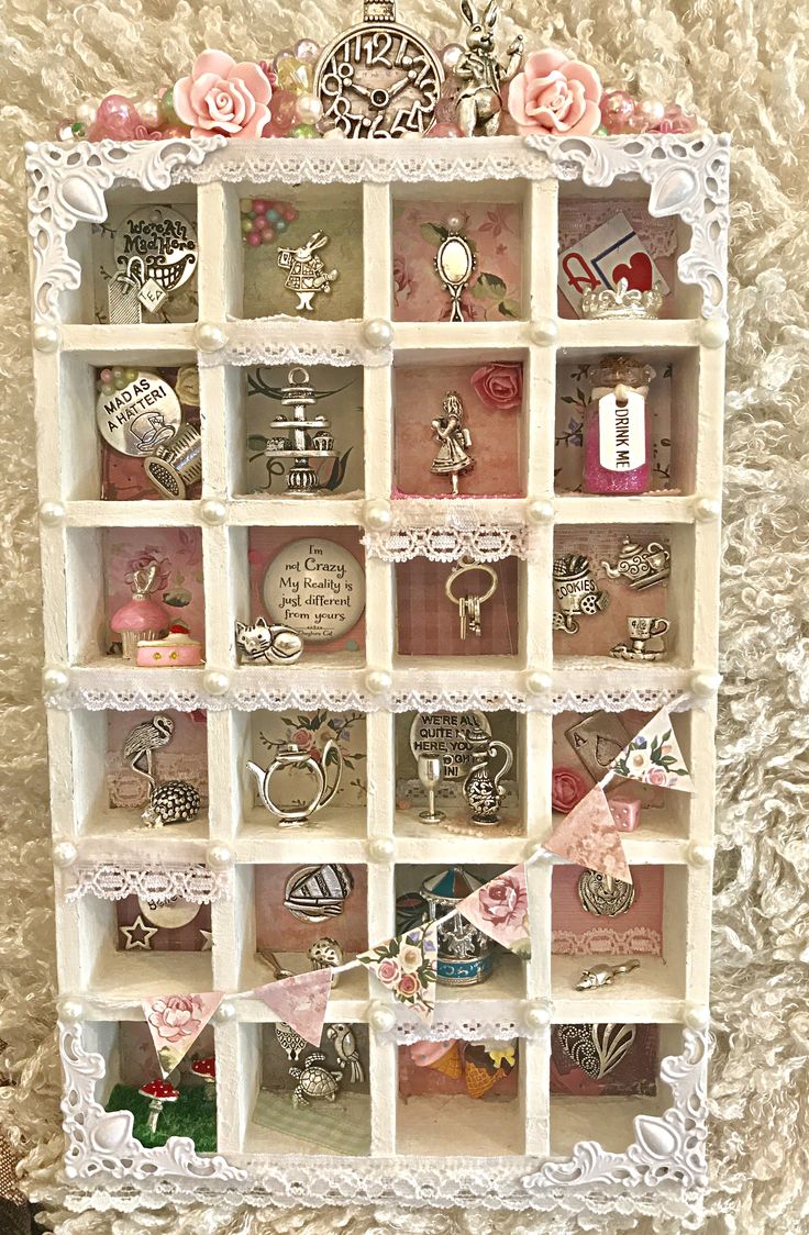 a display case filled with lots of different types of rings and bracelets on top of a white wall