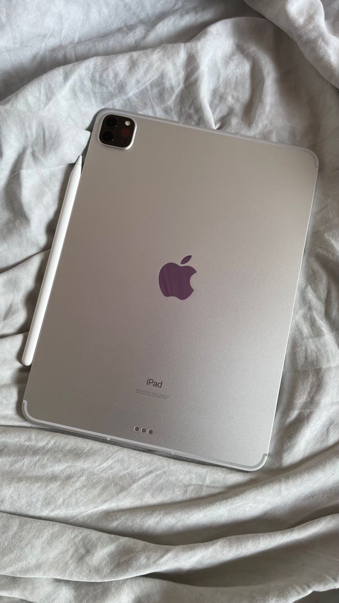 an apple ipad sitting on top of a bed