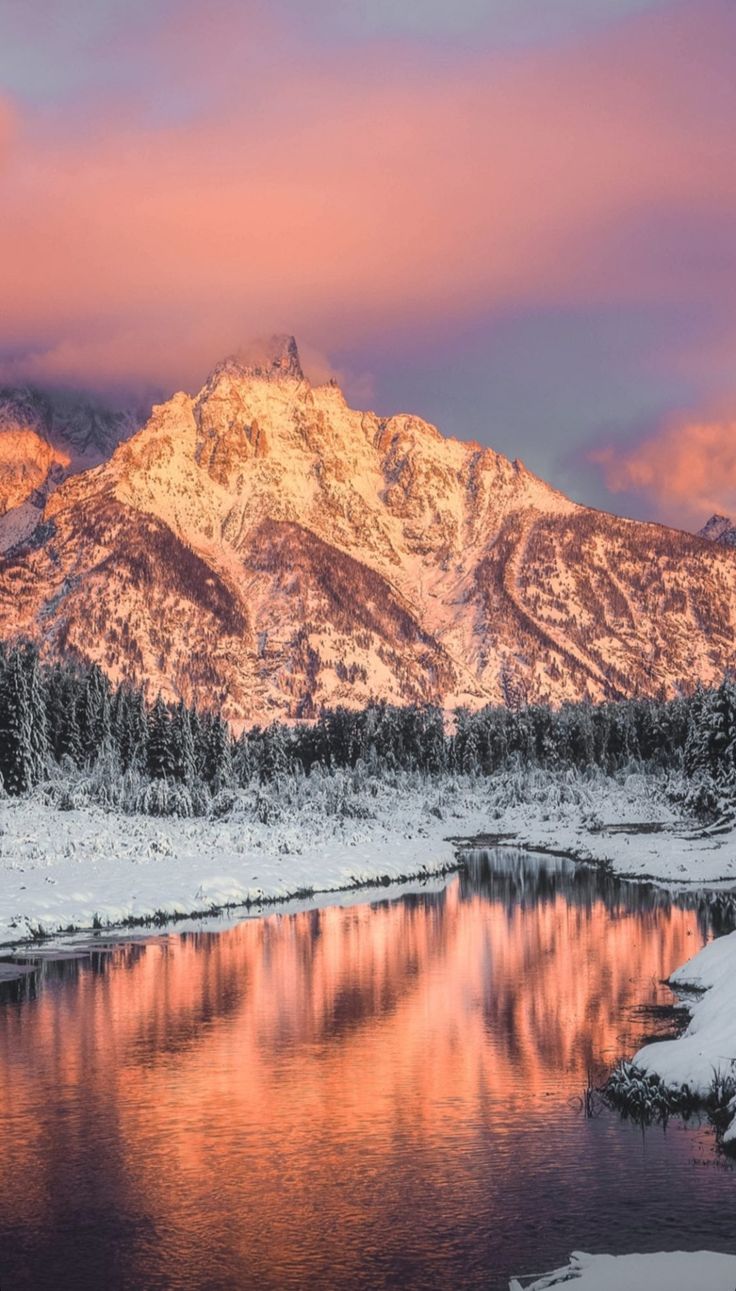 the mountains are covered in snow and reflecting water