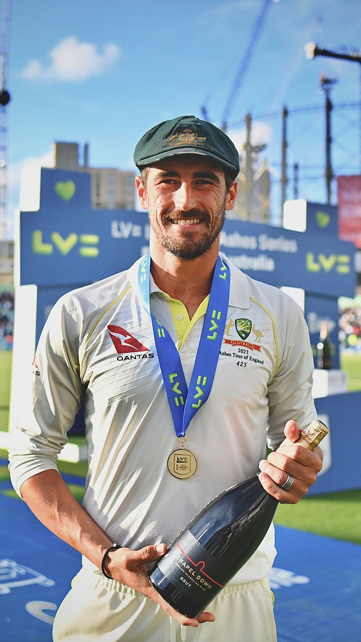 a man holding a bottle and wearing a hat