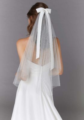 the back of a bride's wedding dress with a veil on her head and shoulder