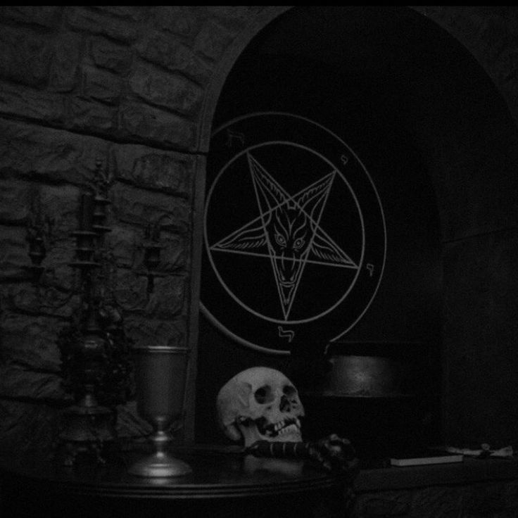 a black and white photo with a pentagramil on the wall next to a skull