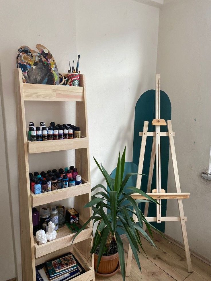 a wooden easel next to a potted plant