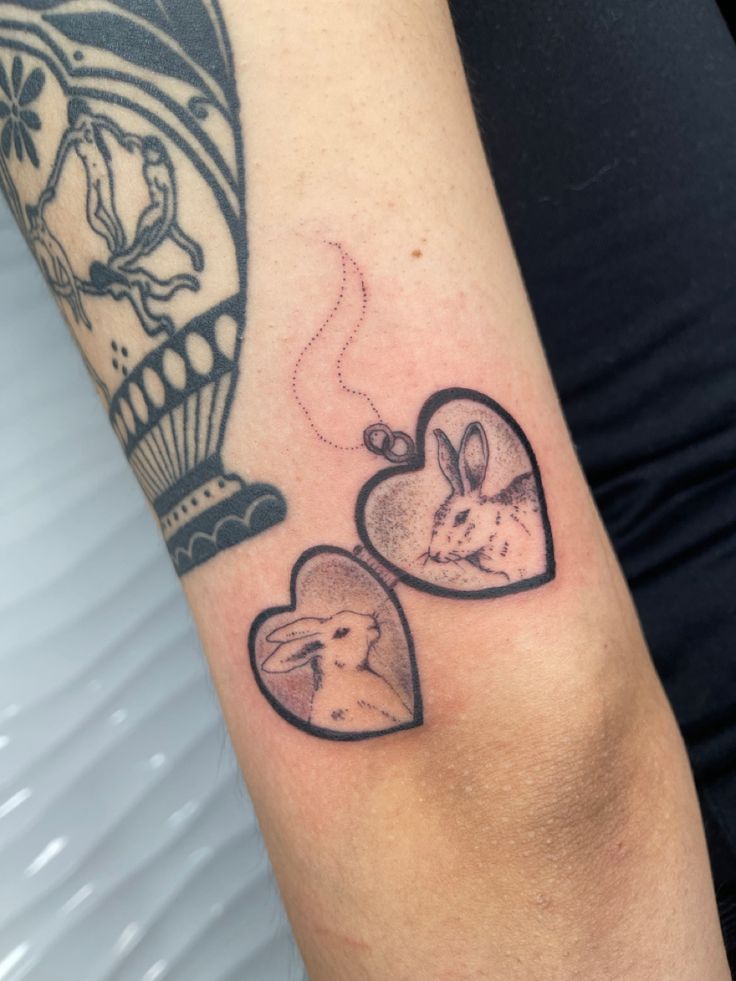 a couple of heart shaped tattoos on the arm