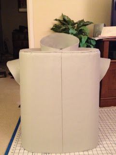 a white chair sitting on top of a tiled floor next to a planter in a living room