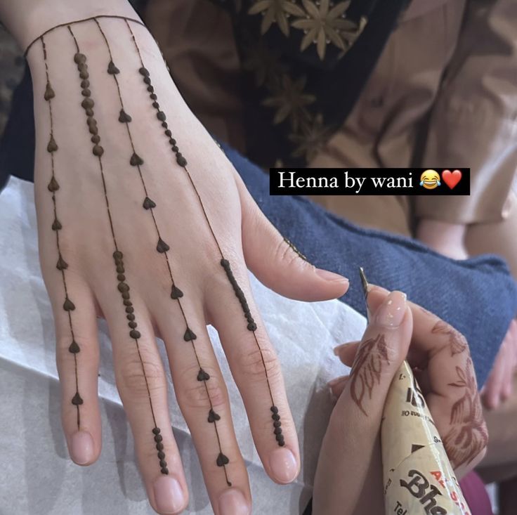 a woman with henna on her hand and bracelets attached to her wrist,