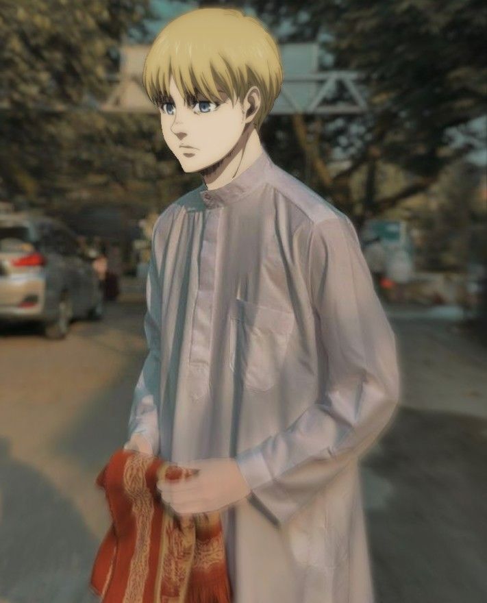 a man with blonde hair and blue eyes is standing on the street in front of cars